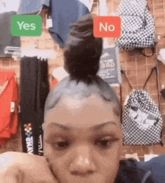 a woman with a bun on her head is standing in front of a wall with backpacks and a sign that says yes or no .