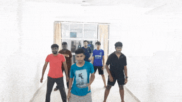 a group of young men are dancing in a room and one of them is wearing a shirt that says ' supreme '