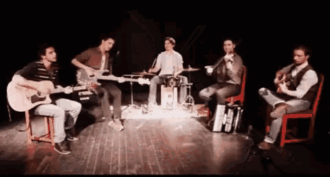 a group of men are playing guitars on a stage