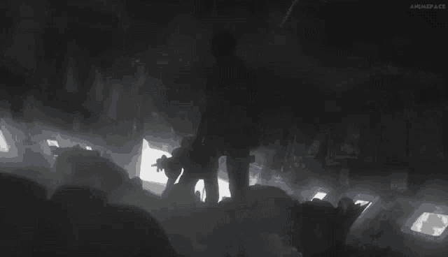 a silhouette of a man with a gun in a dark room .
