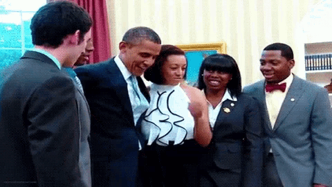 a group of people standing around a man in a suit