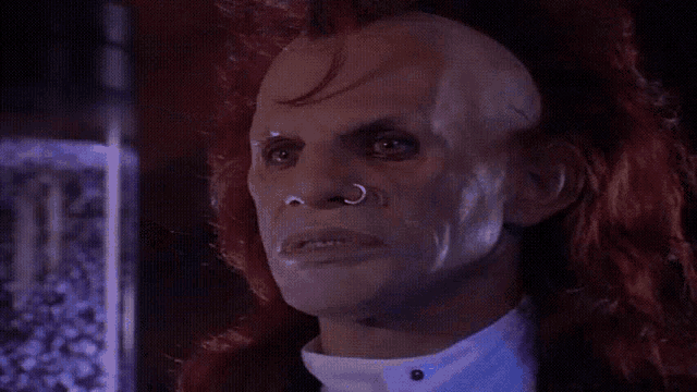 a man with red hair and a white shirt has blood dripping from his face