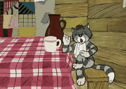 a cartoon cat is sitting at a table with a checkered tablecloth .