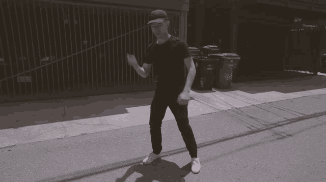a man wearing a black shirt and white shoes is running down the street