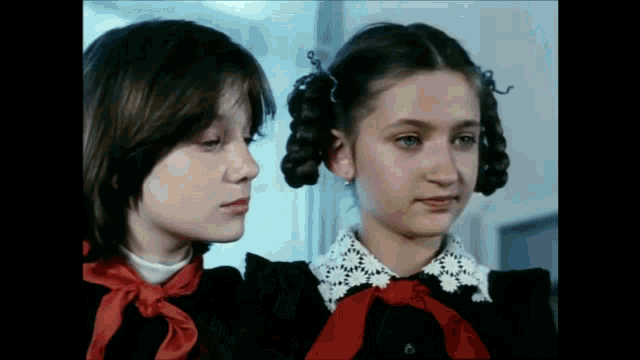 a boy and a girl are standing next to each other and looking at something