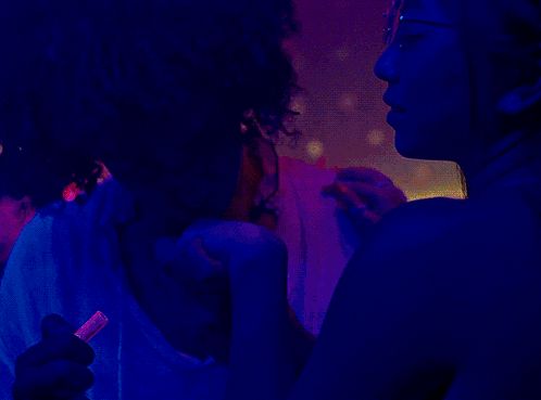 a man and a woman are dancing in a dark room with blue lights