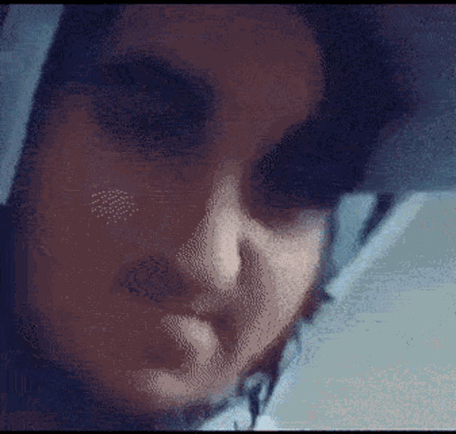 a pixelated close up of a woman 's face with a blue background