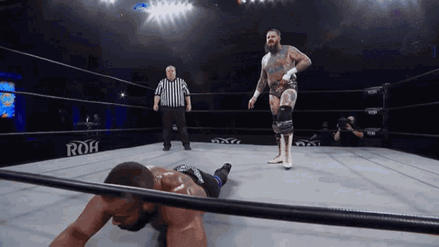 two wrestlers in a ring with a sign that says roh