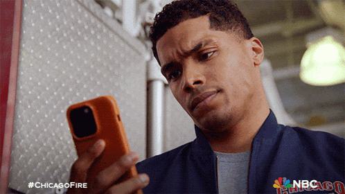 a man wearing a chicago fire jacket looks at his phone