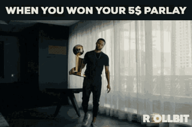 a man holding a trophy in front of a window with the words " when you won your 5 $ parlay " above him