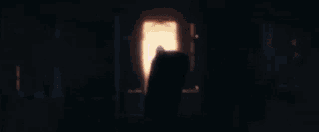 a woman is smoking a cigarette in a dark room while holding a lollipop in her mouth .