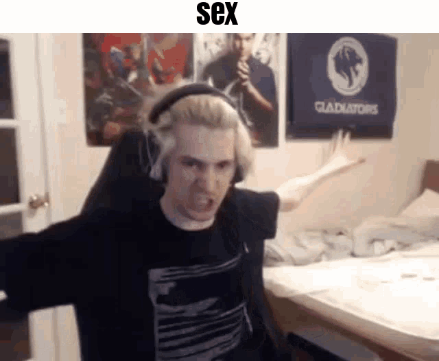 a man wearing headphones is sitting in a chair in front of a bed in a bedroom .