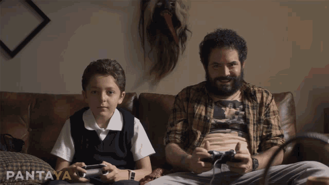 a man and a boy sit on a couch playing video games with pantaya written on the bottom