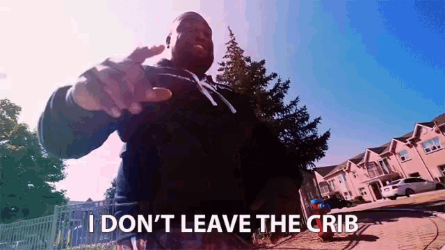 a man says " i don t leave the crib " in front of a row of houses
