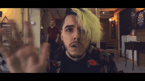 a man with yellow hair and a beard is making a funny face