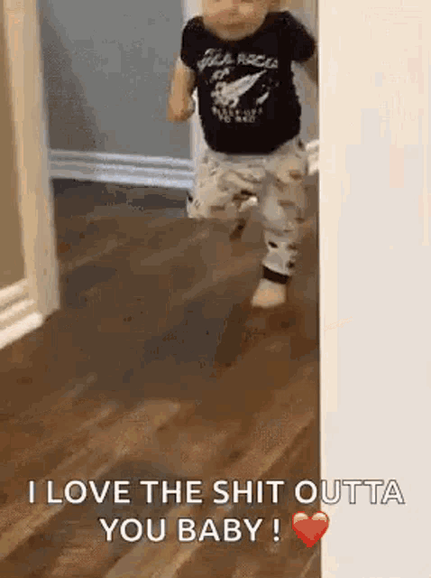 a baby is walking on a wooden floor in a hallway .