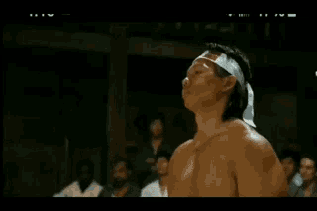 a man without a shirt is wearing a headband with a chinese flag on it
