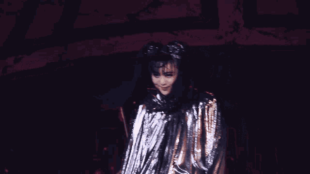 a woman in a silver dress with a crown on her head