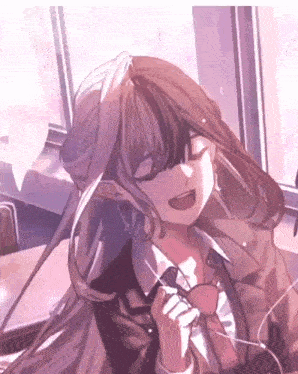 a girl with long hair is sitting in front of a window and smiling .