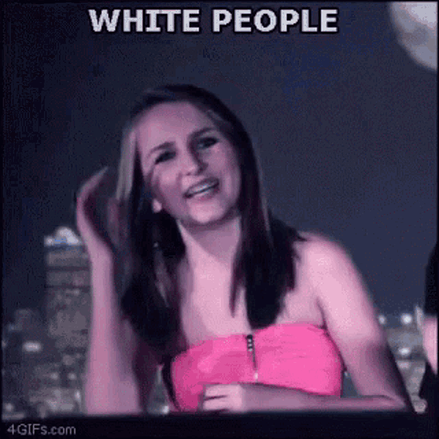 a woman in a pink top is smiling in front of a sign that says `` white people '' .