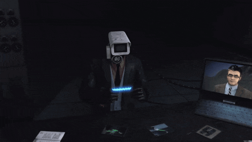 a man with a camera on his head is sitting in front of a laptop computer
