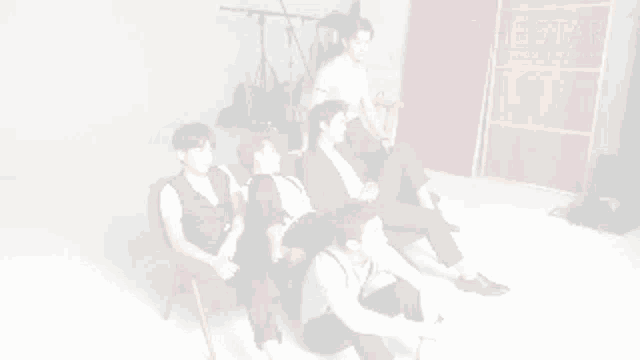 a group of young men sit in chairs in front of a red wall that says the star