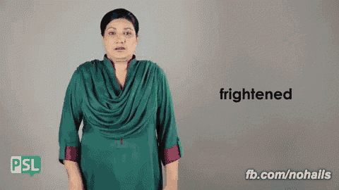 a woman in a green dress is frightened