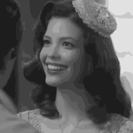 a black and white photo of a woman wearing a crown and smiling .