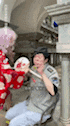 a man in a gray shirt is sitting next to a woman in a pink wig holding a plate .