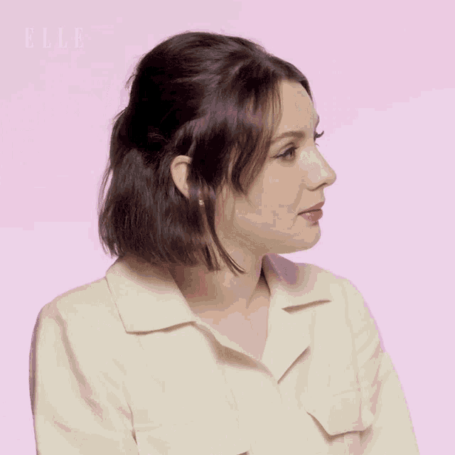 a woman wearing a white shirt with the word elle on the bottom left