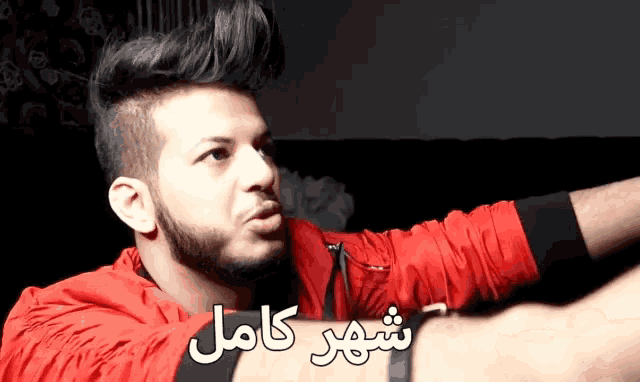 a man in a red jacket with arabic writing on it