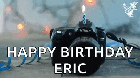 a nikon camera with a candle on it and the words `` happy birthday eric ''