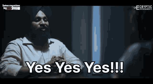 a man in a turban is sitting at a table and says " yes yes yes "