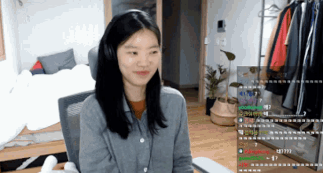 a woman wearing headphones is sitting in front of a computer screen with a bunch of people watching