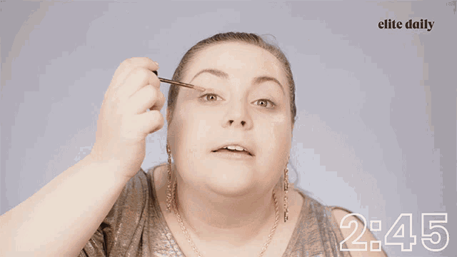 a close up of a woman covering her face with her hand and the words elite daily at the bottom