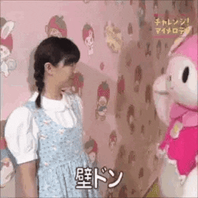 a girl is standing next to a stuffed animal .