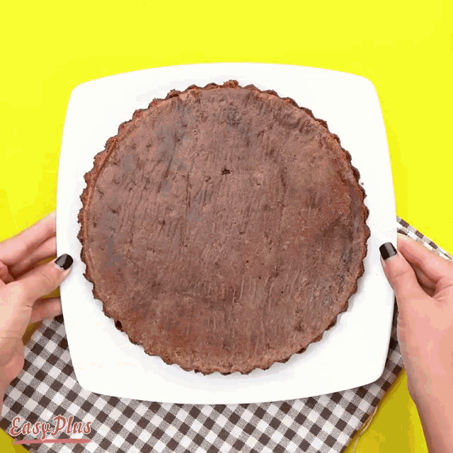 a person is holding a white plate with a cake on it and the words easy plus on the bottom