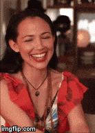 a woman in a red dress is smiling with her eyes closed