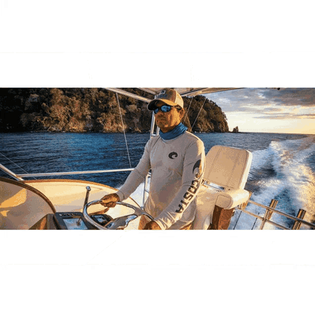 a man wearing a costa shirt is driving a boat in the ocean