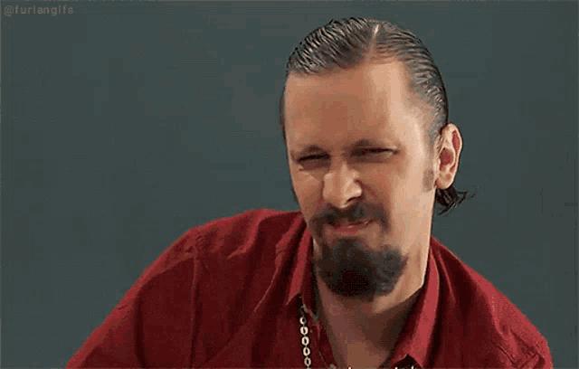a man with a beard and tattoo on his arm is making a fist