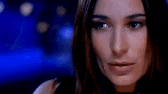a close up of a woman 's face with a tear running down her cheek .