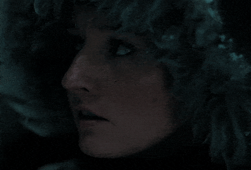 a close up of a woman 's face with a hood on