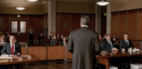 a man is giving a speech in front of a group of people