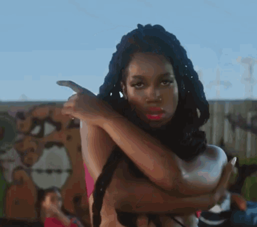 a woman with braids is pointing her finger at something