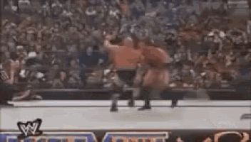a wrestling match is being shown on a television screen with a w logo on it .