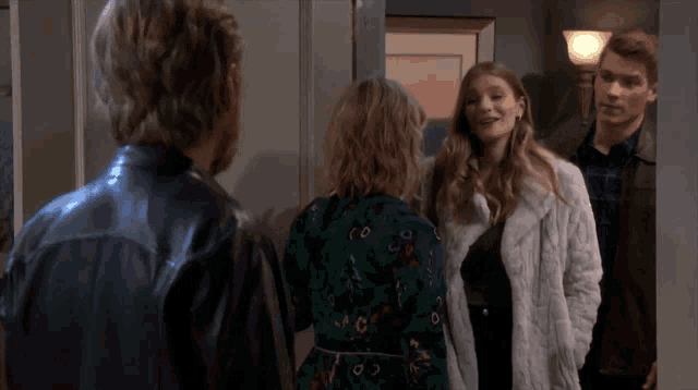 a group of people are standing in a hallway talking