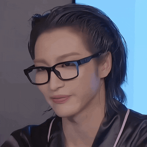 a close up of a person wearing glasses and a black shirt