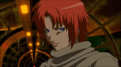 a man with red hair and blue eyes looks at the camera