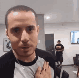 a man with a ring on his finger is standing in a room .
