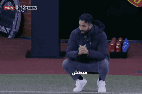 a man squatting on a soccer field with a score of 0 to 2 new